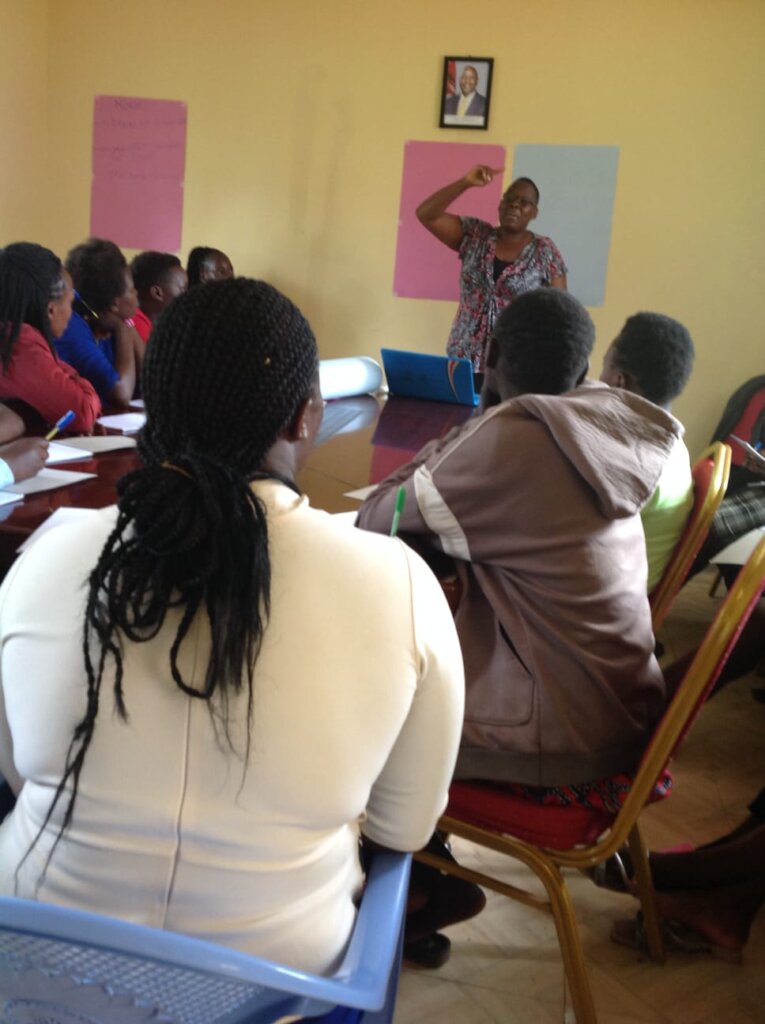 Facilitator guiding teen mothers through learning