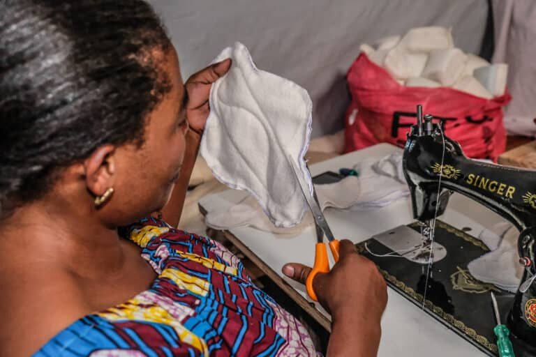 A seamstress sewing reusable sanitary pads.