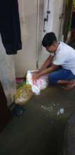 KE staff fortifies his home's door with sandbags