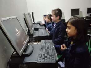 close-up of school children at computers.