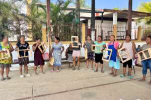 Mujeres sosteniendo moldes para fabricar ladrillo