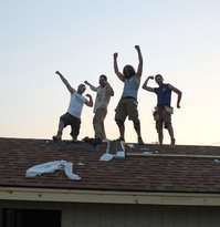 Volunteers pose on the roof of the new cat house