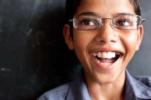 Krishan, a student smiling about his new glasses.