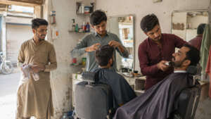 Three young men operating their barbershop