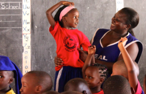 A teacher with students at Real Quality Jr School