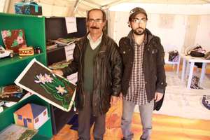 Mohammed helps a student show off his art.