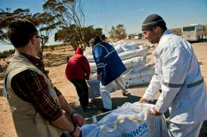 UNHCR and Tunisian volunteers carry tents