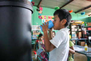 A young student drinks filtered water