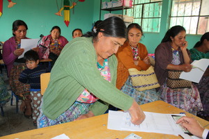 A mother signs her daughter's scholarship receipt.