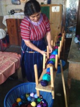 Juanita gets her thread ready to weave.