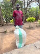 Beneficiary with a bag of maize meal
