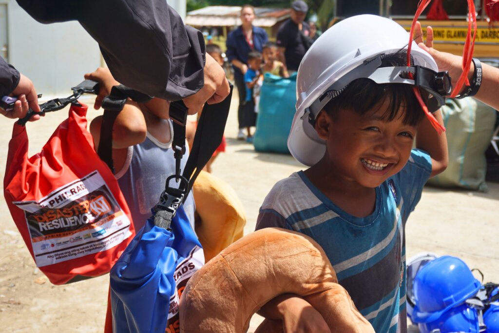 A child tries on the helmet from the disaster kit