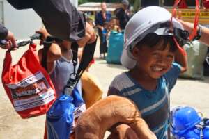 A child tries on the helmet from the disaster kit