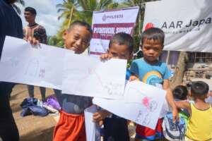 Children showing their drawings.