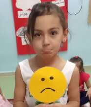 A child holding a sad face