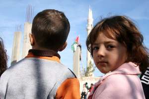 Children watching the Palestinian flag be raised