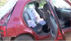 Battered red car with DIEF bags, 2024