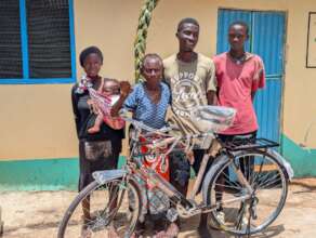 Tizo & her family in front of their new home.