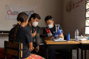 Dr. Inaba (right) talks to patient w/ interpreter