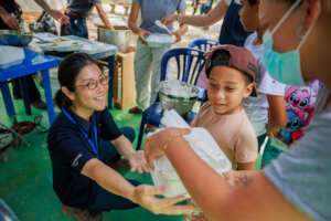 Staff & evacuees at hot meal event (July 2026)