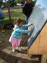 Jessa, solar heater recipient, warms to her panel