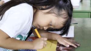 A child writes her name - she owns the book!