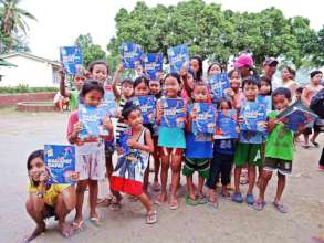 Children in Alitagtag show off their new books.