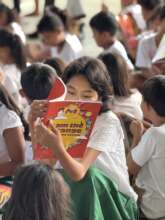 A student in Mangandingay starts on her book.