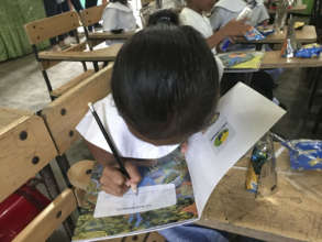 The children write their names on their books.