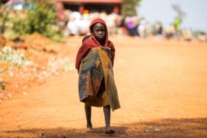 A young girl carries a baby reflecting struggle