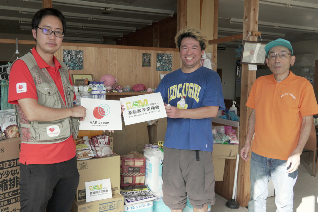 Staff members smiling after receiving relief items