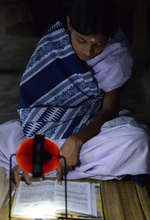 Hasina Khatun using her new solar lamp