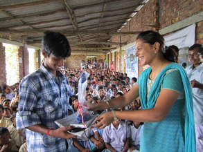 A student receiving a lamp from Ekta of ONergy