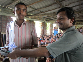 Student receiving a lamp from Sushanta of BTS