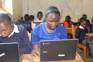 Students wearing headphones and using laptops.