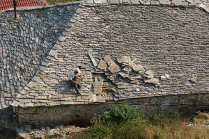 Workers still practice traditional roofing methods