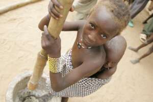 Little girl pounding yam floor for launch