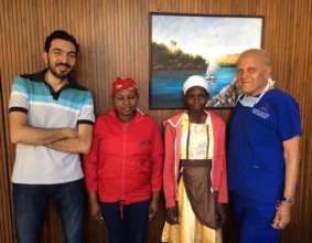 Wairi (white headband) stands next to Prof. Yacoub