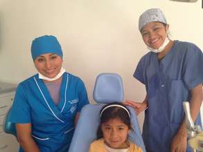 Dr. Nayda A. in blue dental cap & Hygienist Adela
