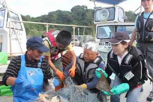Volunteers and locals catch fish together.