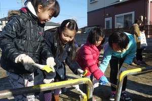 Children painting on playground equipment