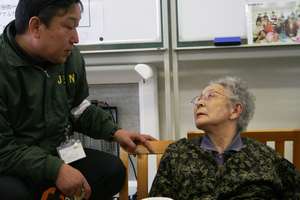 JEN staff visits with a woman in temporary housing