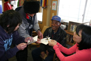 Mari gives cards to Mr. Abe and other residents