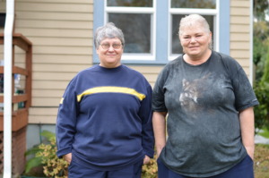 AC and Jeanne in front of their home.