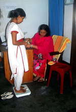 A paramedic taking weight of a patient