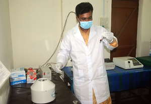 A Pathological Technitian is testing blood-sugar o
