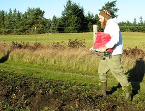 Seth spreading native grass seed by hand