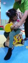 Jasmine is playing the wooden horse on her playtim