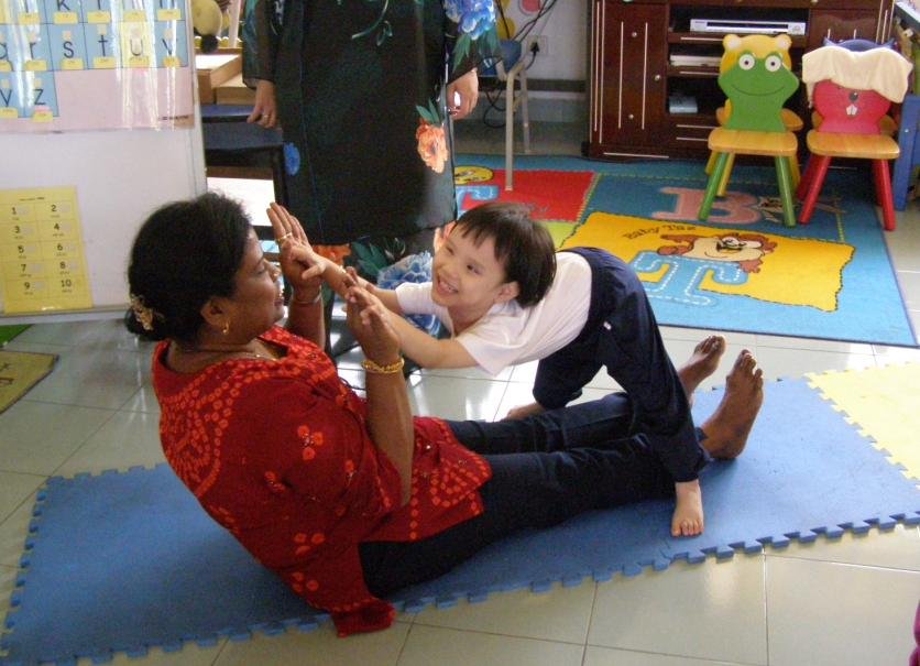 Ms. Jaya playing with a kid during a home visit