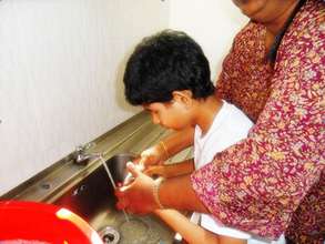 Thurga being trained to wash her hands after meal
